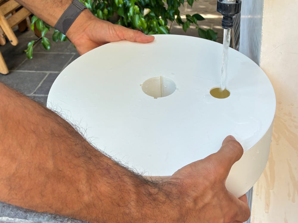Filling the Odisc plate with water from an outdoor tap