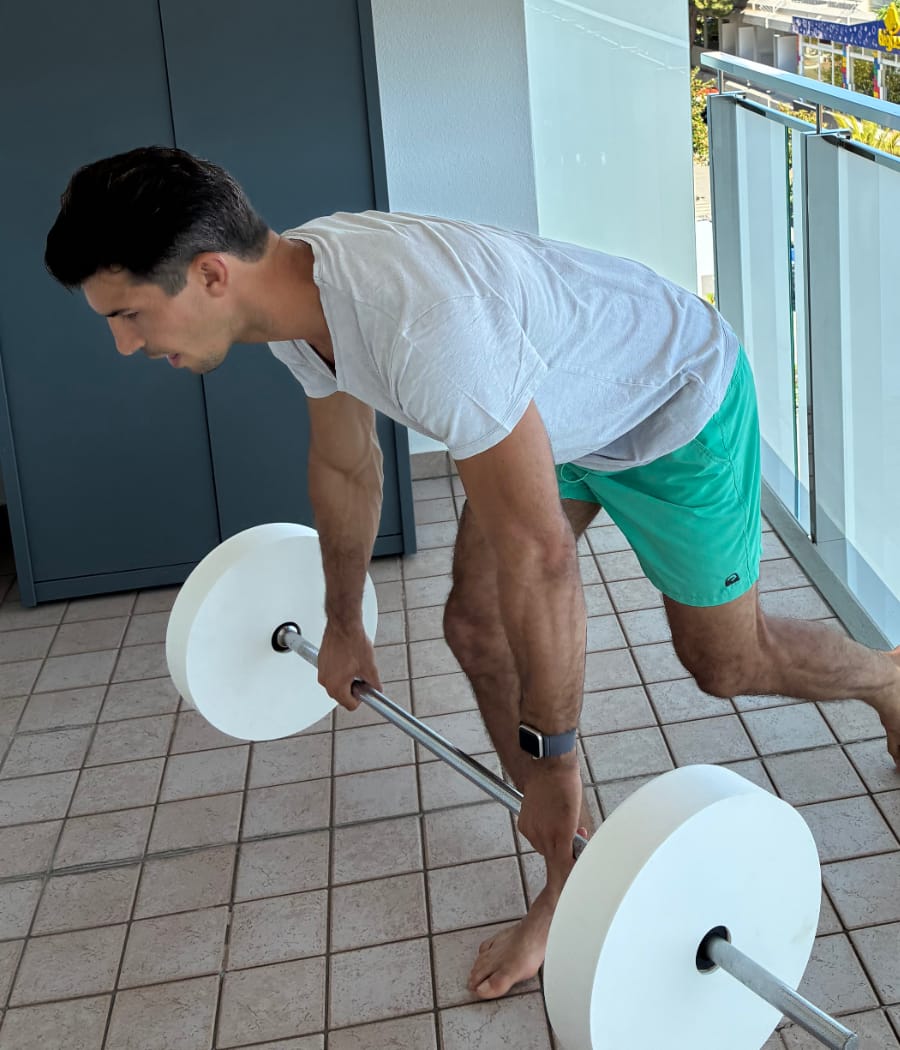 Person performing an RDL with the Odisc plate on a balcony